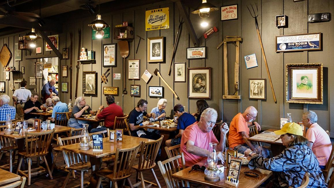 cracker barrel customers eat with antiquities on wall 2
