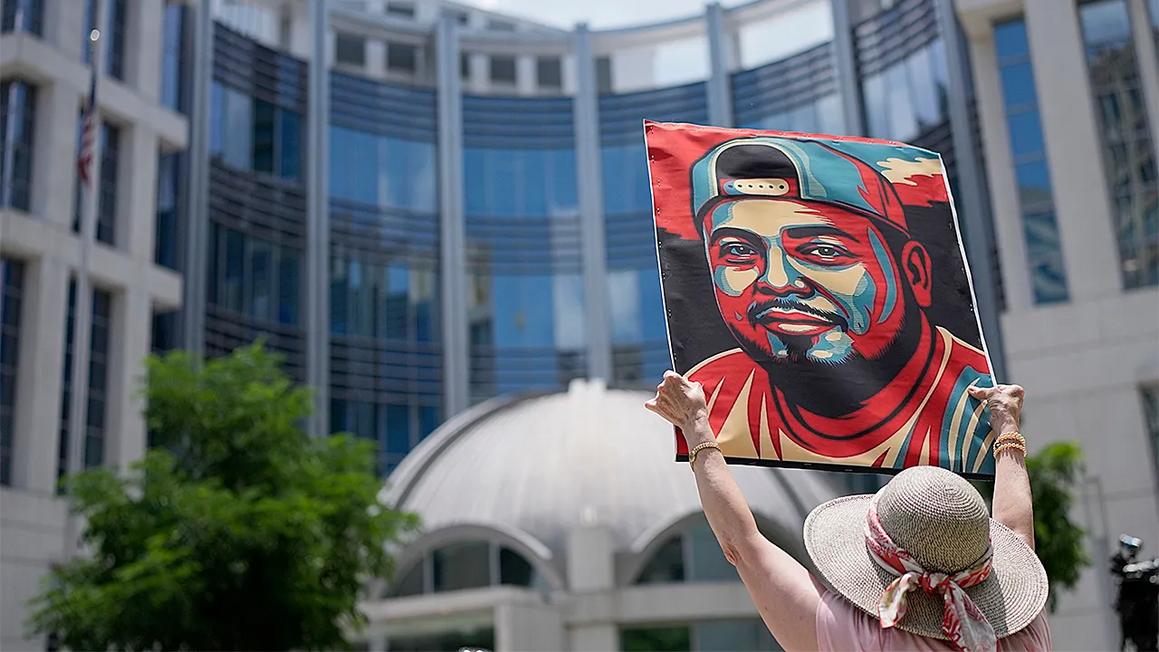 woman holds kilmar abrego garcia protest sign
